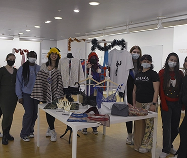 A class of Fashion & Textiles students with the items on display in their pop-up shop